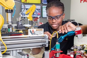 Student Janell McFarland working with advanced manufacturing equipment